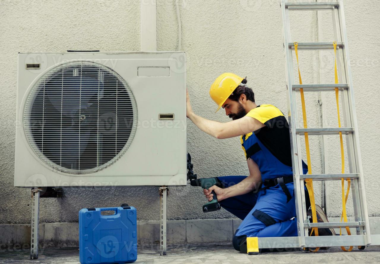 Competent repairman starting work on defective air conditioner, using  handheld drill to disassemble condenser metal coil panel. Precise mechanic  dismantling hvac system to check for dirt 32624395 Stock Photo at Vecteezy